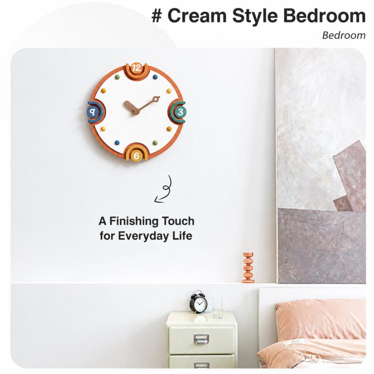 Modern orange-rim wall clock with cream dial and colorful number markers above bedside