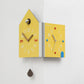 Yellow double-faced corner wall clock, house shape with gray knob and multicolor numeral dots