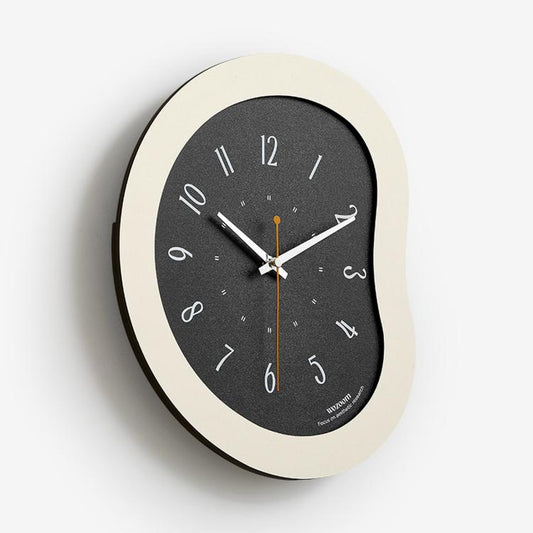 Cream-framed modern wall clock with dark face, curved casing, number markers