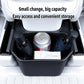 Rear seat storage box holding drinks and items in the open compartment, dark