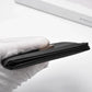 Black slim bifold wallet edge with smooth inner lining, metal clasp side