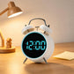 White twin-bell digital alarm clock with blue glowing ring and blue LED time display