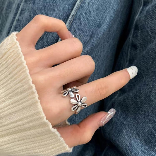 Adjustable sterling silver daisy open ring with flower charms on finger