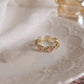 Close-up of adjustable gold-tone heart ring with pink cat-eye stones and sparkle hearts
