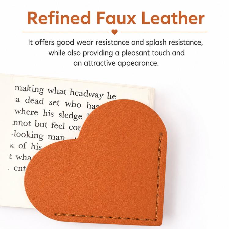 Orange heart-shaped bookmark corner clip on an open book, stitched faux leather