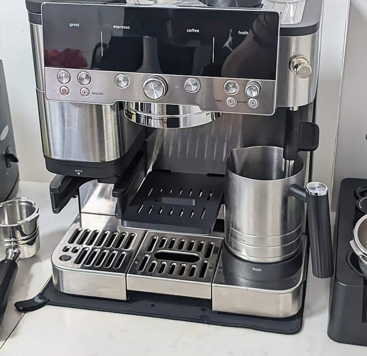 Black drip tray protective cover installed on coffee machine cup tray