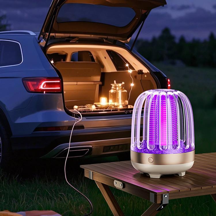 Golden beige electric mosquito killer lamp on outdoor table with purple UV light