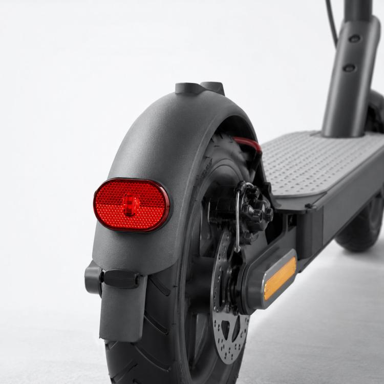 Red oval tail light mounted on gray scooter rear fender