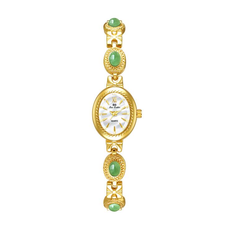 Gold oval analog quartz watch with green stone accents and chain bracelet