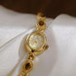 Gold oval analog quartz watch with brown stone pendant-style bracelet links
