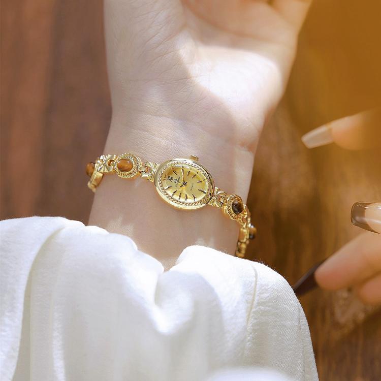 Gold oval dial bracelet watch with linked chain band, vintage analog quartz face