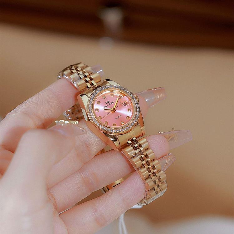 Two-tone analog wristwatches on hand: rose-gold tone and crystal-studded bezel