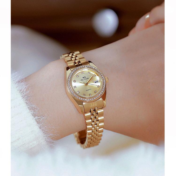 Women's gold-tone analog wristwatch with rhinestone bezel, date window, steel band