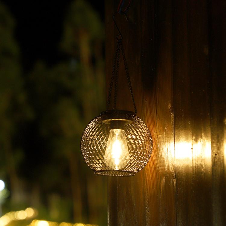 Glowing black wire globe hanging lantern with warm light inside