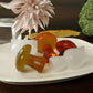 Mushroom-shaped resin or wax pieces in amber orange and white on grooved stems
