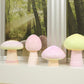 Mushroom-shaped resin or wax pieces in pink and pale yellow with grooved stems