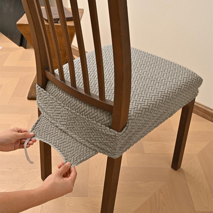 Matcha green textured dining chair seat cover being fastened with elastic and buckles