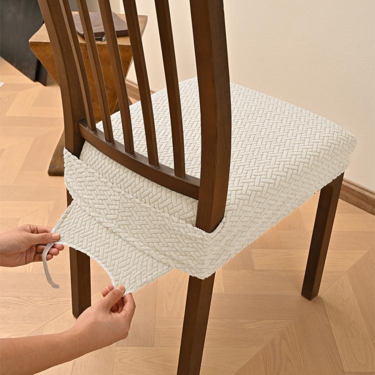 Beige textured dining chair seat cover with elastic hem and buckle tabs