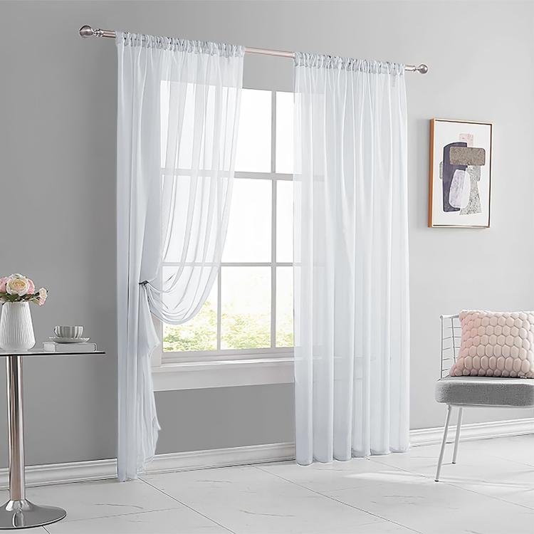 White sheer rod pocket voile window curtain set with gathered top and flowing pleats.