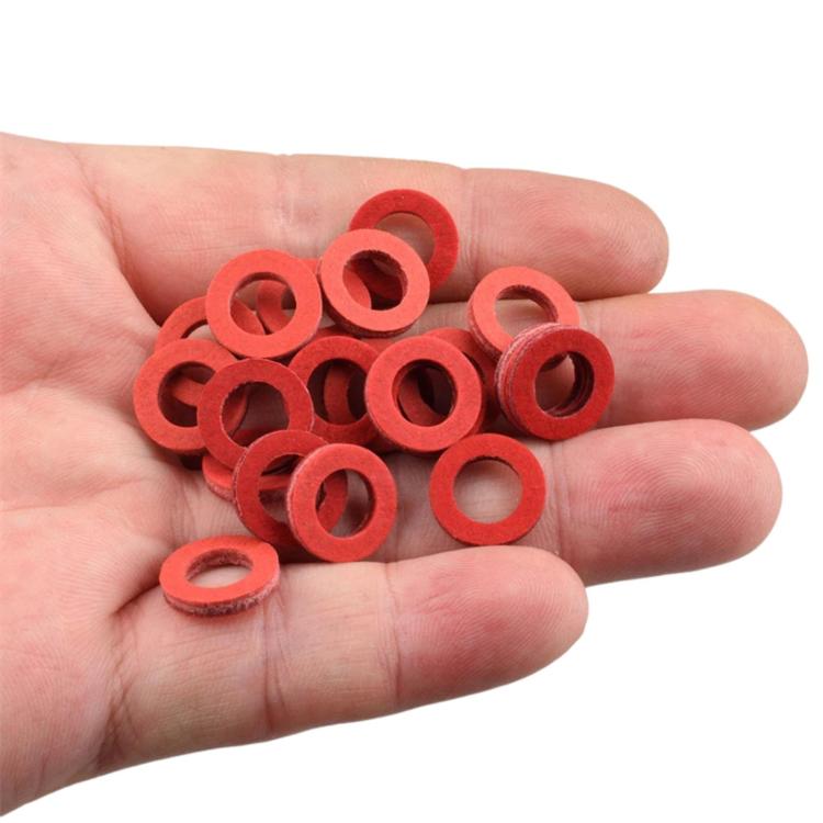 Red drain screw gasket washers in hand, small sealing rings with center holes