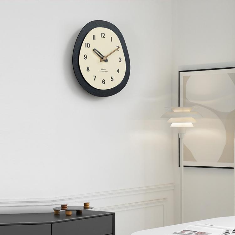 Modern oval wall clock with dark outer ring and cream dial showing numbered hours