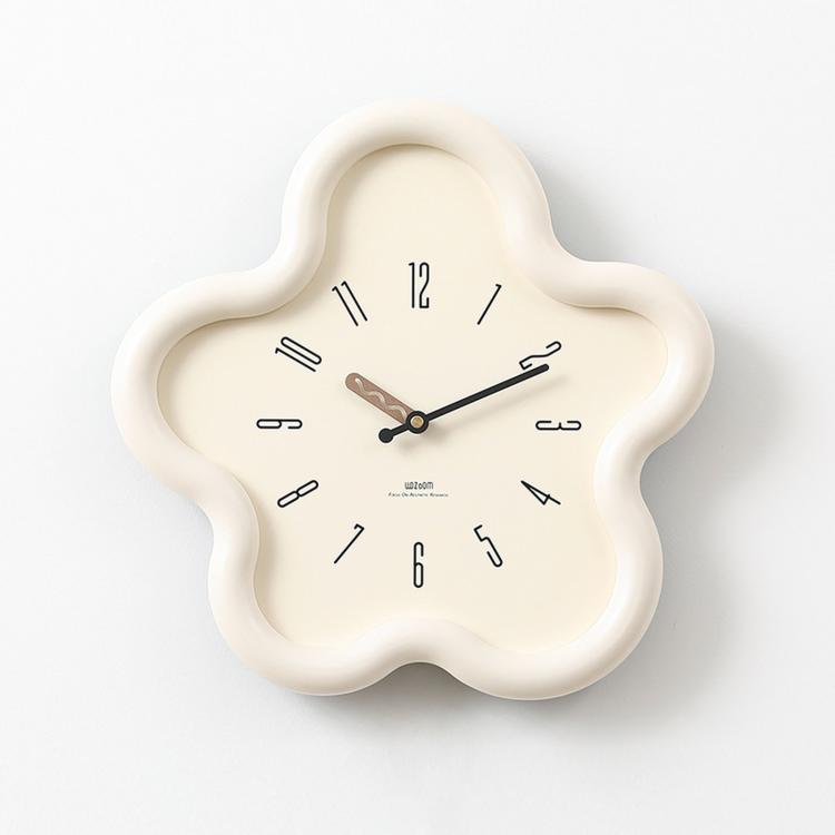 Flower-shaped wall clock with cream frame, beige face, black hands and Arabic numerals.