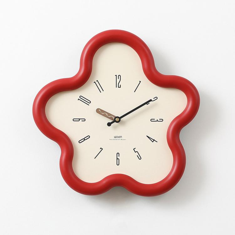 Flower-shaped wall clock with red frame, cream face, black hands and Arabic numerals.