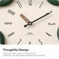 Close-up of flower-shaped wall clock face with black hands, Arabic numerals, and logo.