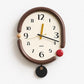 Retro oval wall clock, brown frame with yellow and black hands and dangling black tag