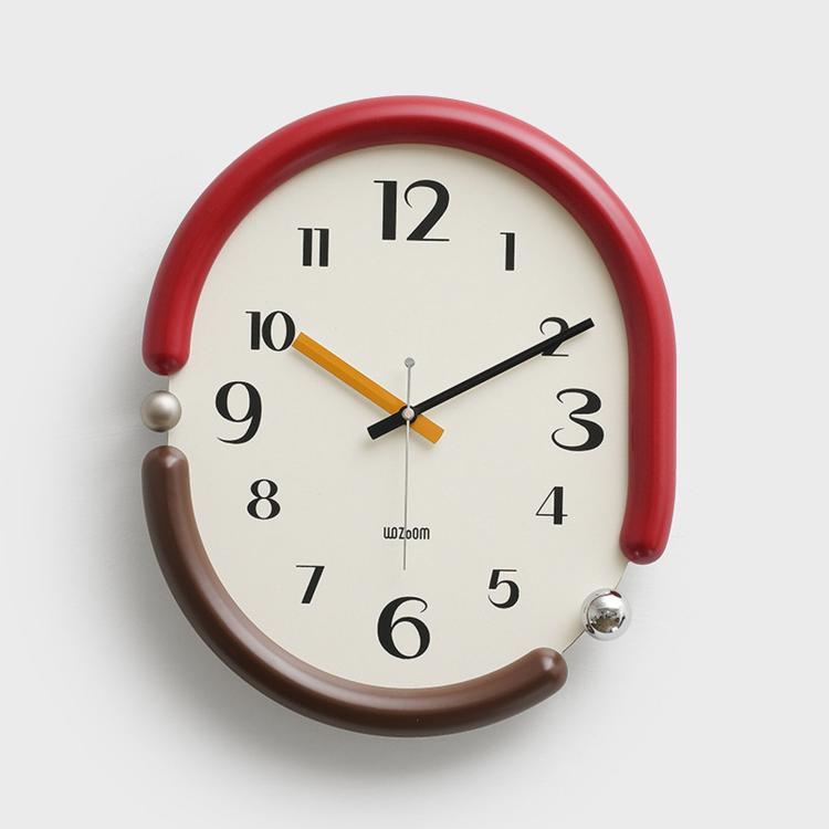 Retro oval wall clock with red frame, cream dial, brown and black hands.
