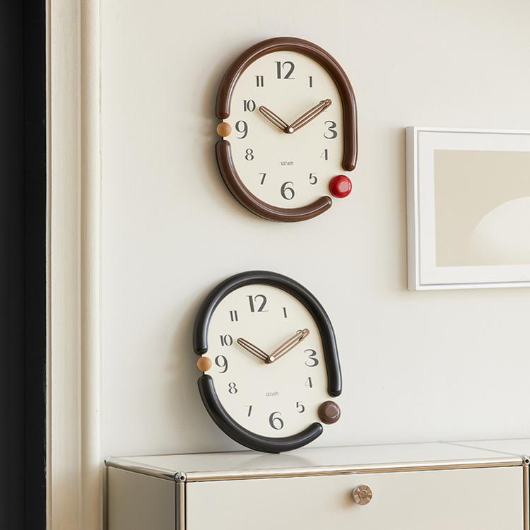 Two retro oval wall clocks: one dark brown and one black with cream dials.