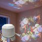 White LED projector light on three feet, power button visible, metal keyring attached