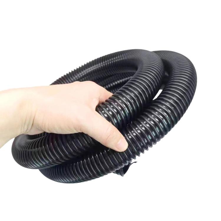 Coiled ribbed vacuum hose held in hand, flexible corrugated design