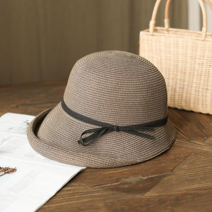 Grey straw cloche sun hat with black ribbon bow on dark band, foldable style