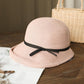 Light pink straw cloche sun hat with black ribbon bow on dark band, foldable style