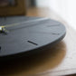 wozoom silent wall clock, close-up angled view of gray dial with black line markers and hands