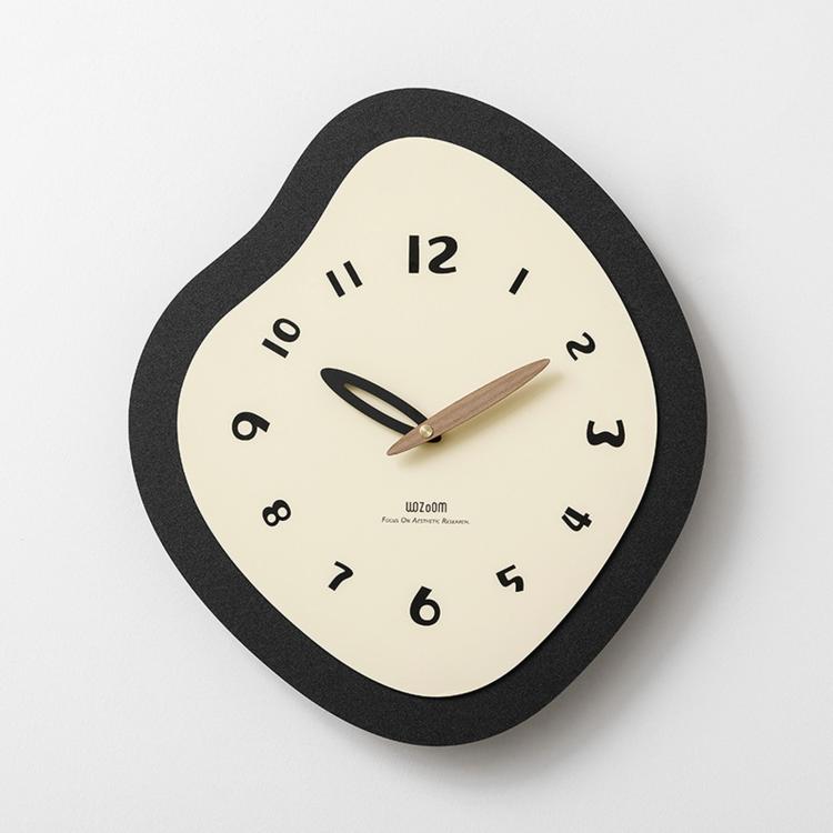 Irregular wall clock with black frame, cream dial, and gold hour and minute hands.