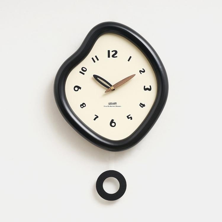 Irregular wall clock with glossy dark frame and cream dial, plus mounting ring piece.