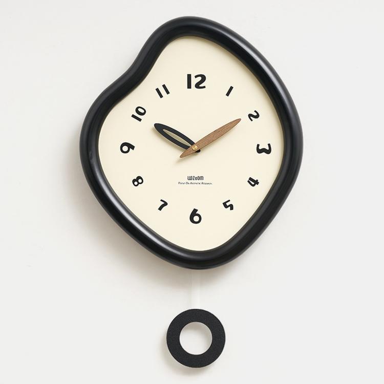 Irregular wall clock with glossy dark frame, cream dial, and mounting ring shown below.