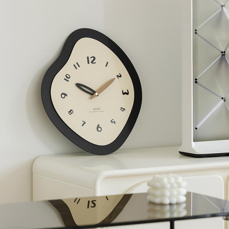 Irregular wall clock with black frame, cream dial, walnut hands, and Arabic numerals