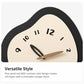 Irregular wall clock close-up with cream dial, black markers, and walnut plus black hands