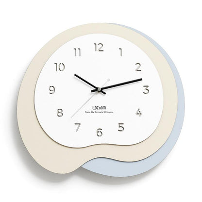 Irregular wall clock with beige frame and light blue outer ring, black hands and markers