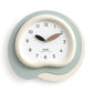 Irregular wall clock with white face, sage-green outer ring, black and wood hands