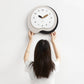 Irregular wall clock held up: white face with black outer ring and wood-toned hands