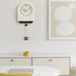 Cream pendulum wall clock with light dial and hanging pendulum weight.