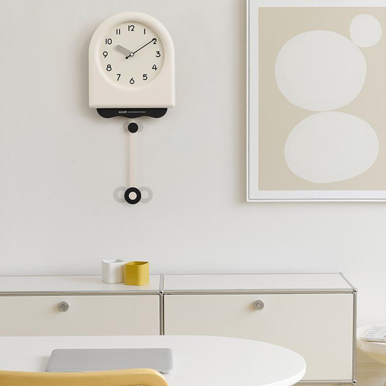 Cream pendulum wall clock with light dial and hanging pendulum weight.