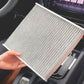 Car air filter element held in hand, gray pleated media with white frame