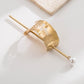 Gold hair bun cuff slide with raised zigzag texture and pearl drop pin