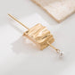 Gold hair bun cuff slide with embossed wave texture and pearl end pin