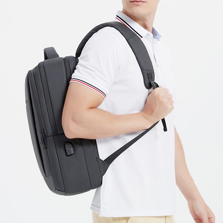 Black laptop backpack worn on person, padded straps and front organizer panel